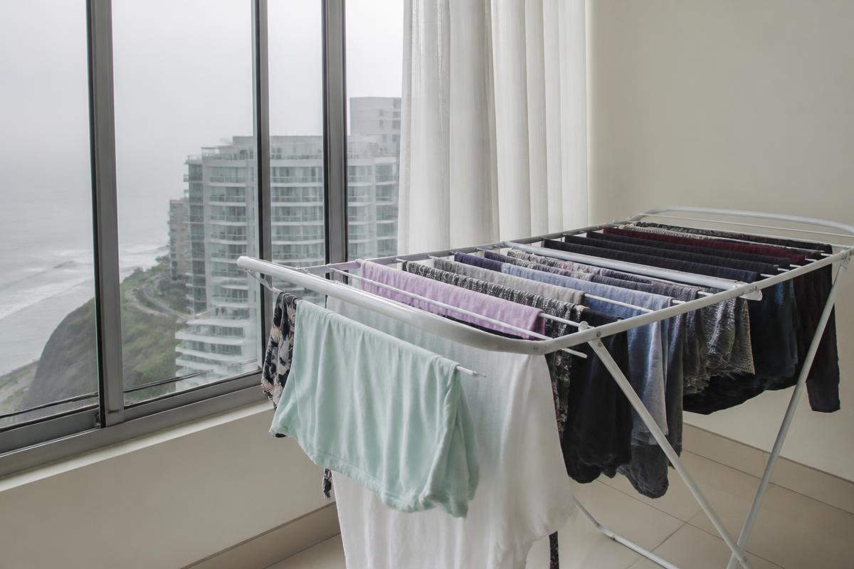 Ropa colgada secándose dentro de un departamento en un día gris de invierno en Lima
